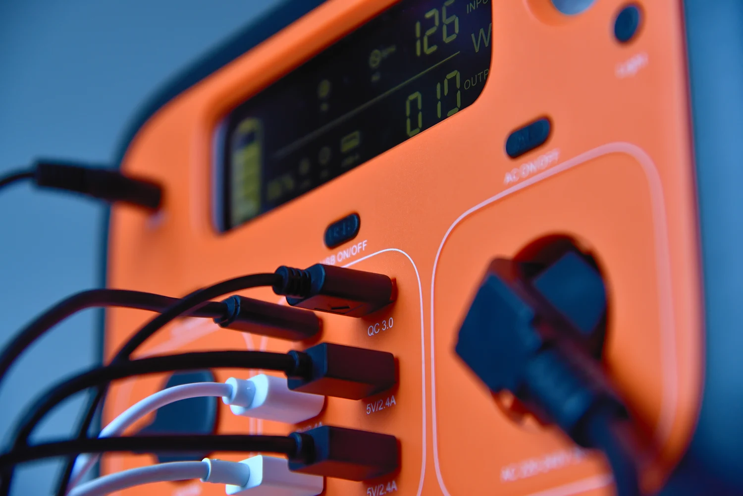 Close-up of the USB ports and connected charging cables on a power station.