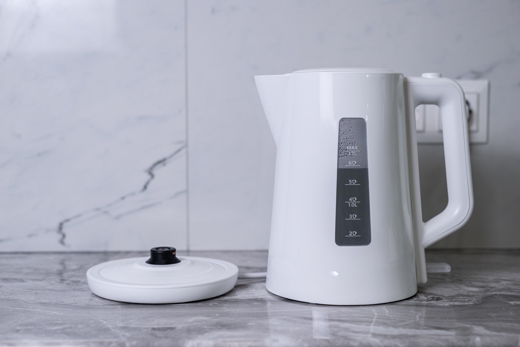 A white electric kettle on a kitchen counter