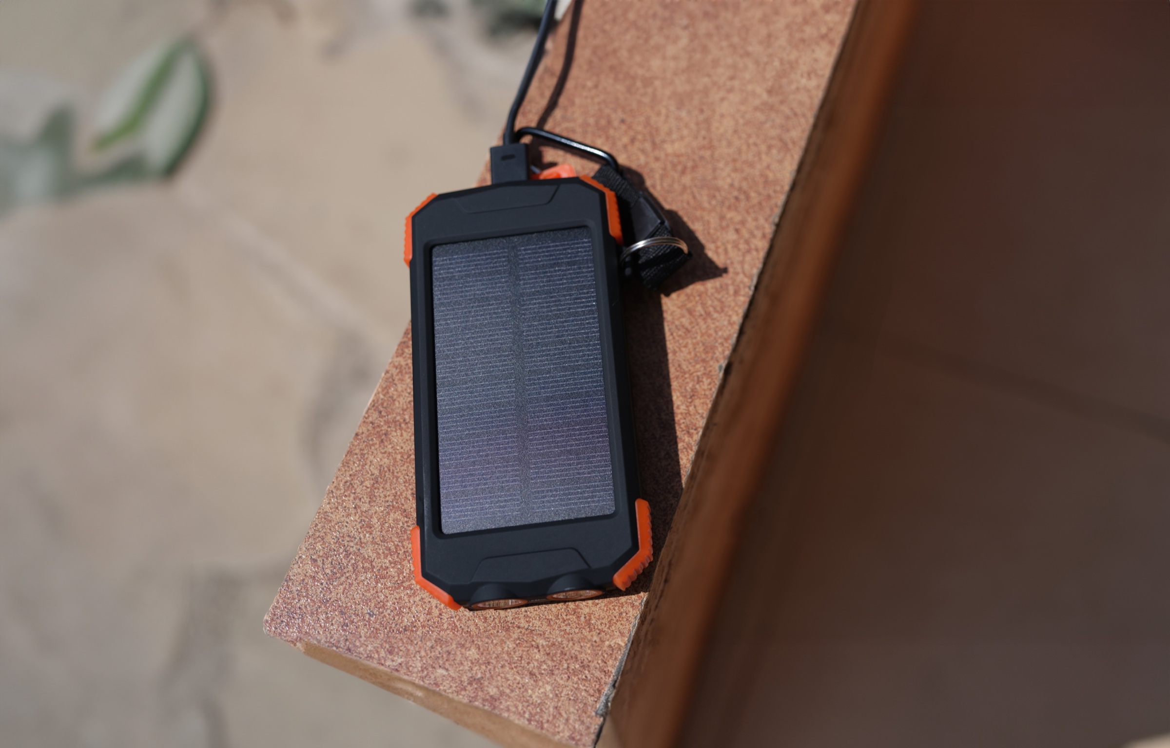 A compact solar power bank recharging outdoors in sunlight