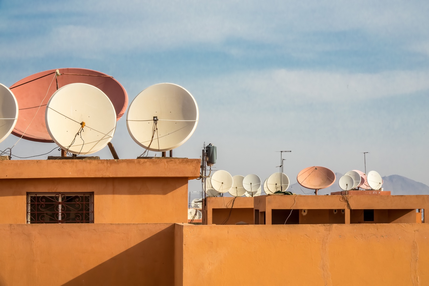 Satellite dishes installed outdoors beneath a clear sky